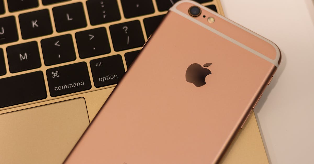 Rose Gold Iphone Placed On A Gold Macbook Keyboard, Highlighting Technology Integration For Strategic Digital Marketing And Social Media Management.